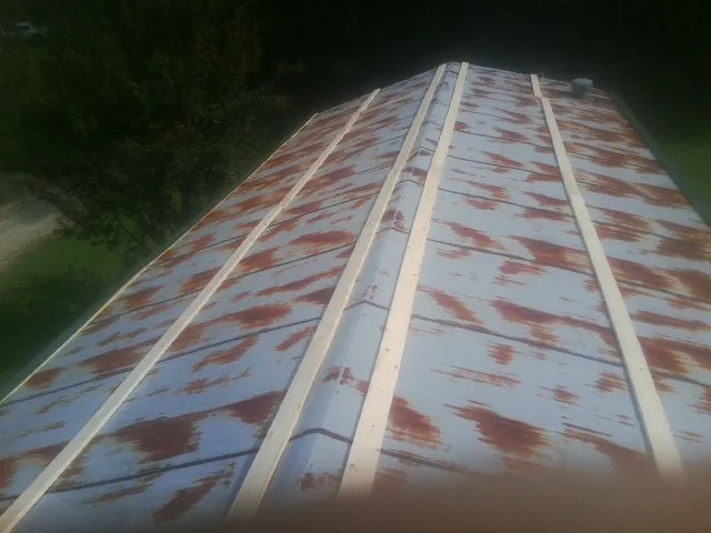 Rusted metal roof panels with new wood purlins before replacement — Storm Damage Roof Repair in Decker by Roofing Brothers