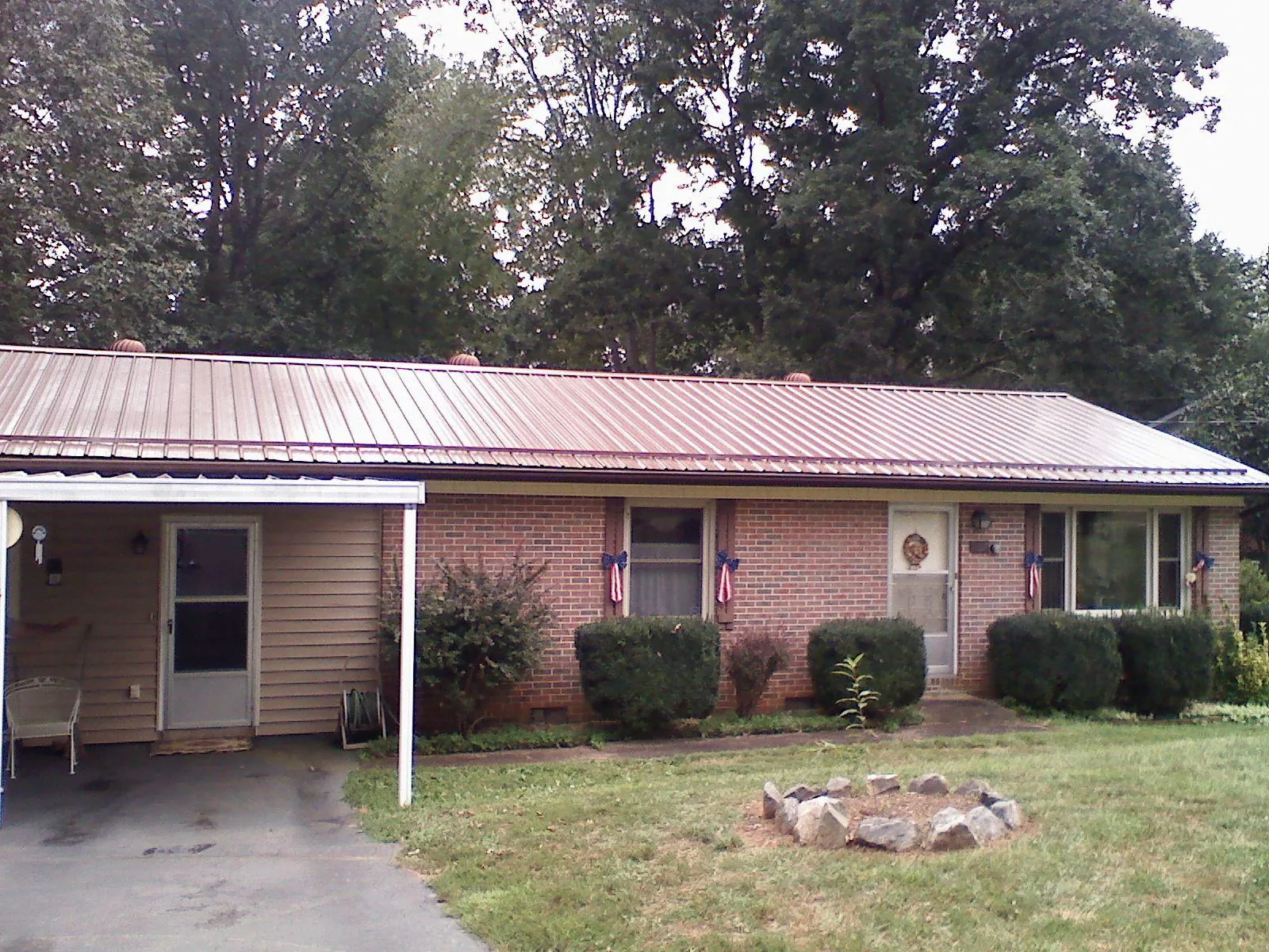 Bronze metal roof and carport on a brick ranch home — Roof Repair work by our crew in Decker